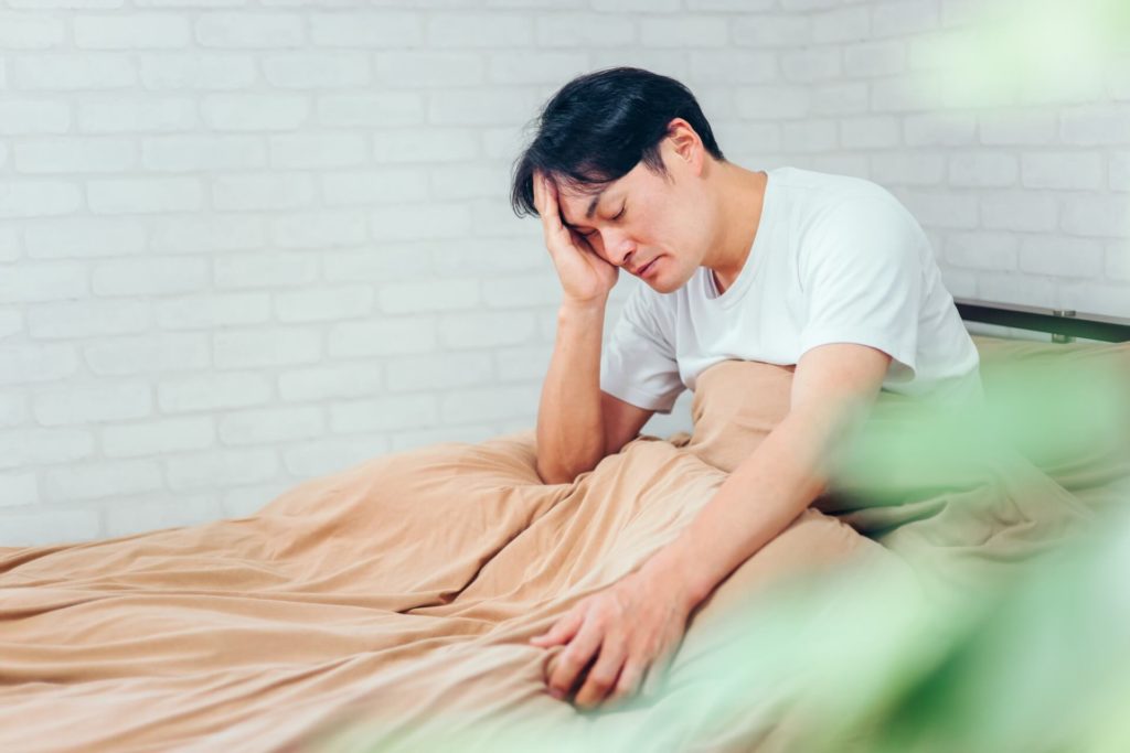 ベッドの上で悩んでいる