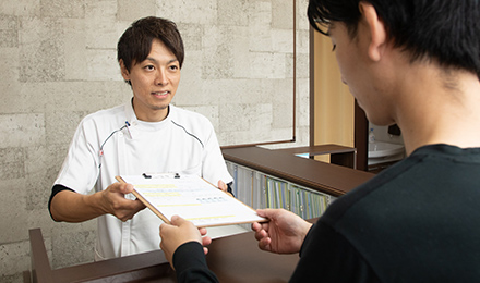 問診表を受け取る風景